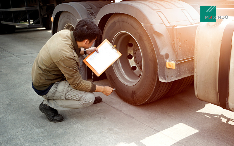 man inspecting truck tyres