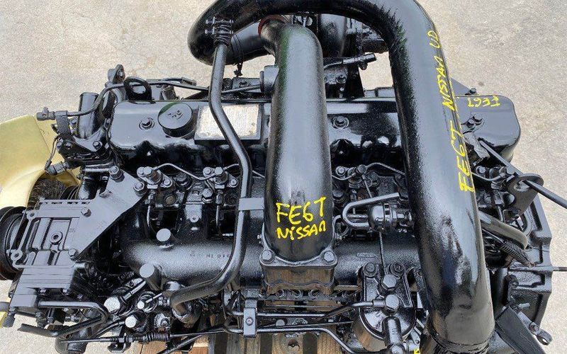 A detailed view of a black FE6T Nissan engine assembly.